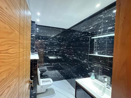 a bathroom with a toilet and a glass wall at Tayyurt Surf Camp Tamraght Aourir in Awrir