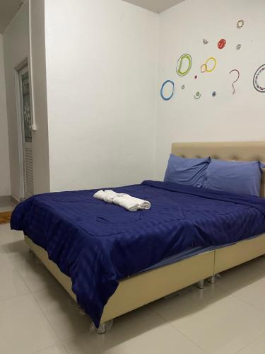 a bed with blue sheets and two towels on it at ควีนเพลส สระบุรี Queenplace Saraburi in Sara Buri