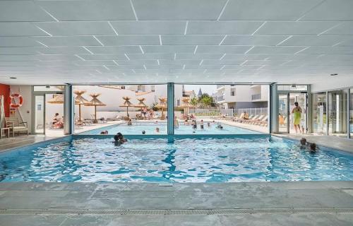 une grande piscine avec des gens dans l'eau dans l'établissement T3 avec Piscine, 150m de l'océan, à Royan