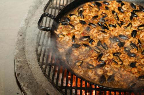 a pan of food cooking on a grill at Hotel Boutique Can Cocal El Cuyo in El Cuyo