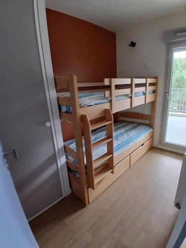 Cette chambre comprend 3 lits superposés et une fenêtre. dans l'établissement T3 avec Piscine, 150m de l'océan, à Royan