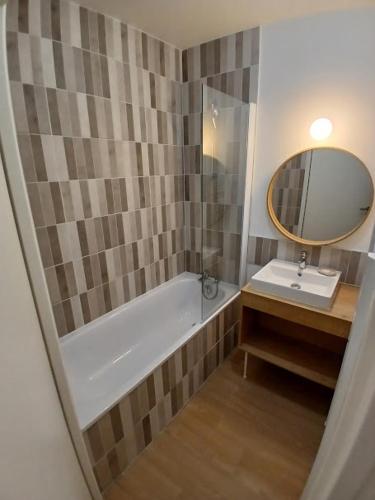 une salle de bain avec une baignoire, un lavabo et un miroir dans l'établissement T3 avec Piscine, 150m de l'océan, à Royan