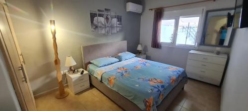 a bedroom with a bed and a dresser and a window at Annie's Apartment in Ialyssos