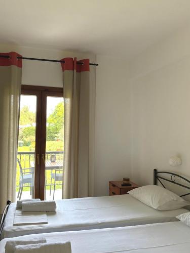 a bedroom with a bed and a balcony at Studios Galanis in Afitos