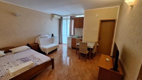 a room with a bed and a table and a kitchen at Ivanovic Family House Apartments in Sutomore