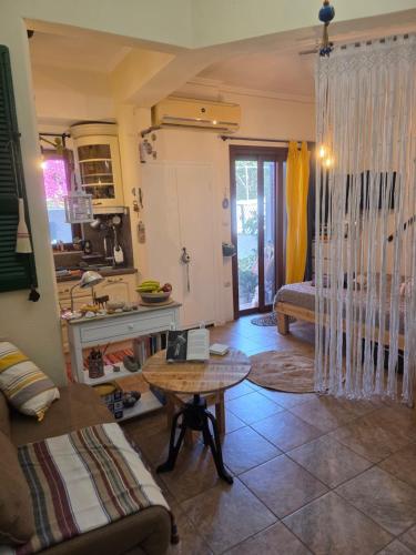 a living room with a table and a kitchen at Peace&love-sea studio in Poros