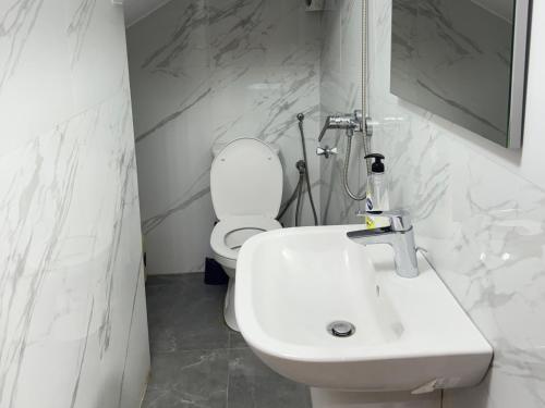 a bathroom with a white toilet and a sink at surf house Agadir in Tama ou Ennza
