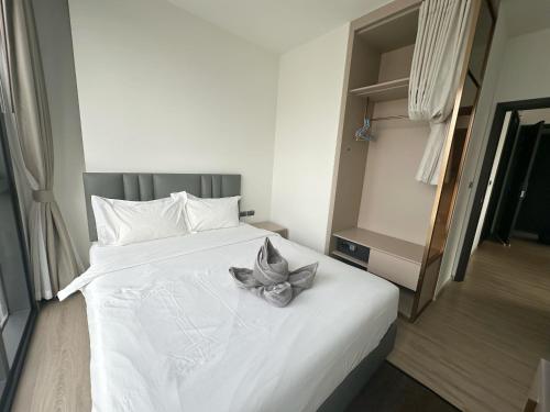 a bedroom with a white bed with a flower on it at The Edge central pattaya in Pattaya Central
