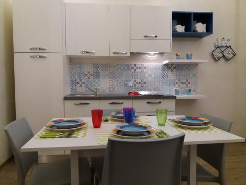 a kitchen with a table with plates and chairs at Scalovecchio in Marettimo