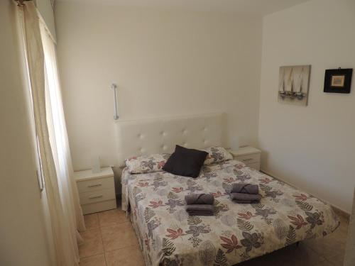 a bedroom with a bed with two towels on it at Accessible Cristimar in Los Cristianos