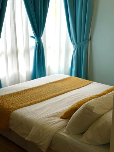 a bed with blue curtains in a bedroom at Mama King’s Homestay@ Palas Horizon in Brinchang