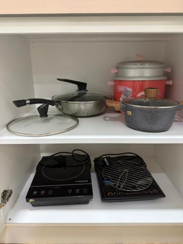 a kitchen shelf with two pans and a stove at Mama King’s Homestay@ Palas Horizon in Brinchang