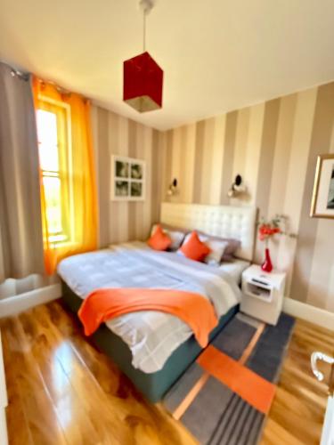 a bedroom with a large bed with orange pillows at Upton Country Park Guest House in Northampton