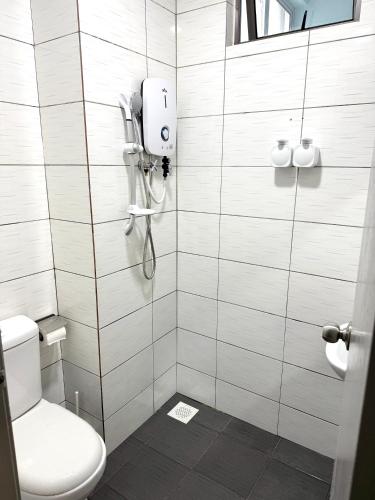 a bathroom with a shower with a toilet and a phone at Mama King’s Homestay@ Palas Horizon in Brinchang