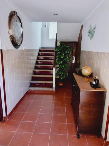 a hallway with a staircase and a clock on the wall at Casa MARIO y MARIOLA in El Dueso