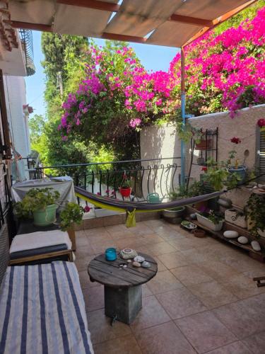 a patio with a table and flowers on a balcony at Peace&love-sea studio in Poros