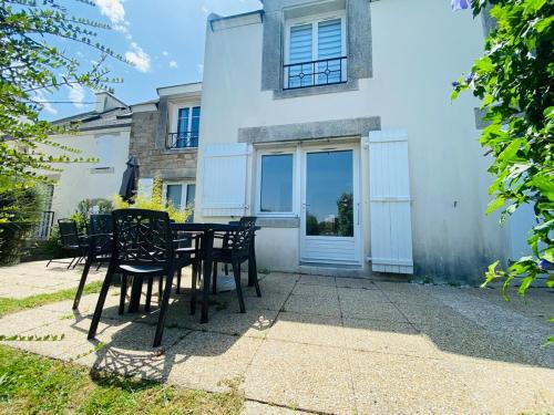 a table and chairs in front of a house at Charmant T2 4 à 5 personnes in Arzon