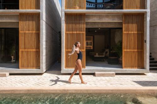 a woman is standing in front of a building at Jiloo Beautiful Oasis in Punta Zicatela 2 in Brisas de Zicatela