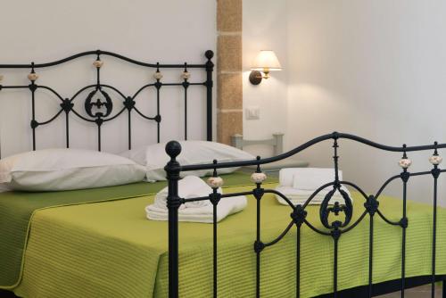 a bedroom with a bed with a green blanket at Masseria Luci Grande in Scorrano