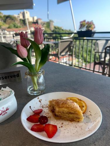 a plate with a pastry and strawberries on a table at --HOTEL DEAL-- Rooms With Castle View in Krujë