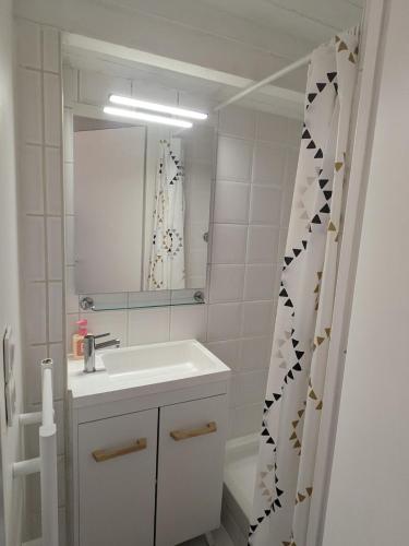 une salle de bain blanche avec un lavabo et un miroir dans l'établissement Studio 3 couchages vue mer, à Châtelaillon-Plage