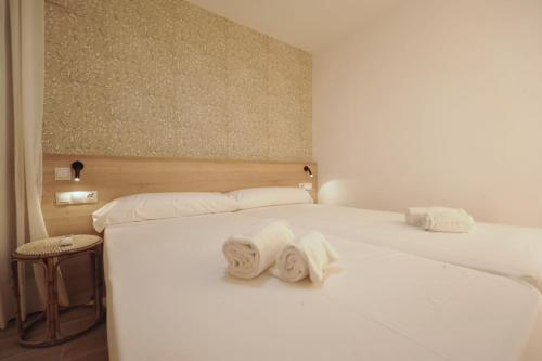 a bedroom with two white beds with towels on them at Orange Park Duplex Atico Premium in Benicàssim