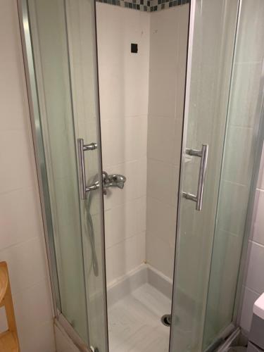 une douche avec une porte vitrée dans une salle de bain dans l'établissement studio cassanyes, à Canet