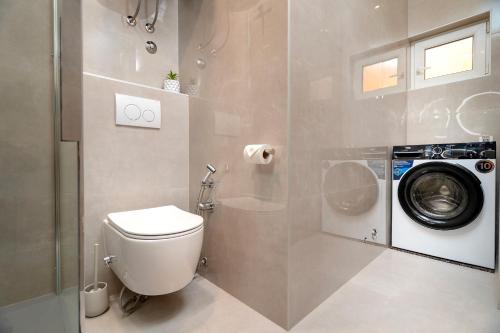 a bathroom with a toilet and a washing machine at Villa Vista in Jelsa