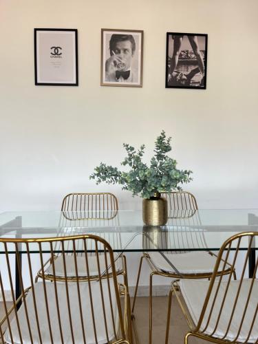 une table en verre avec trois chaises et une plante en pot dans l'établissement Au 5eme ciel, à Draguignan