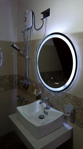 a bathroom with a sink and a mirror at Hilltop Heaven Cabanas 