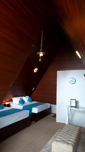 a attic room with two beds and a couch at Hilltop Heaven Cabanas 