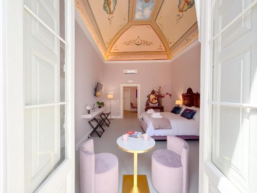 a room with a bed and a table and chairs at Luxury Suite - Free WifI - Smart Tv - centro Storico in Mesagne