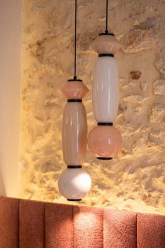 three white glass lights hanging from a wall at Madonna del Mare City in Chania Town