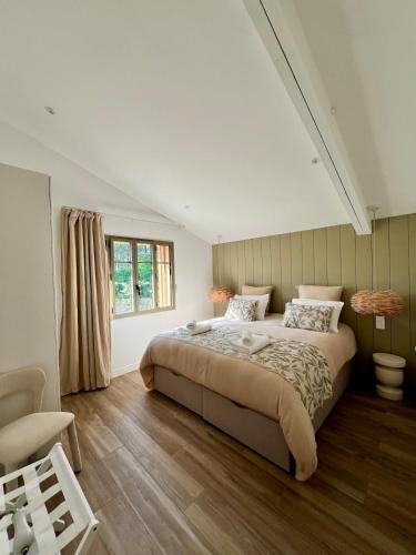 une chambre avec un grand lit et une fenêtre dans l'établissement Villa Piñhat, à Lège-Cap-Ferret