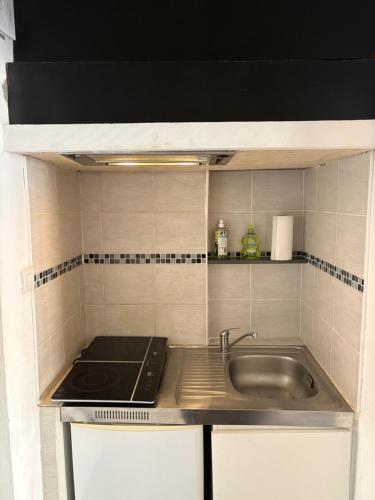 une petite cuisine avec un évier et une cuisinière dans l'établissement Studio proche de la mer, à Canet