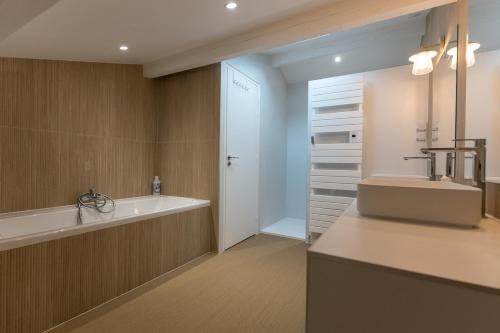 une salle de bain avec un lavabo et une baignoire dans l'établissement Villa Piñhat, à Lège-Cap-Ferret