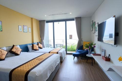a hotel room with two beds and a window at Flamingo Hải Tiến in Gò Ba Quần