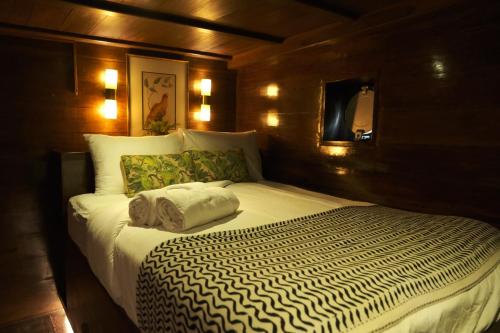 a bedroom with a bed in a wooden wall at Behike Luxury Phinisi in Labuan Bajo
