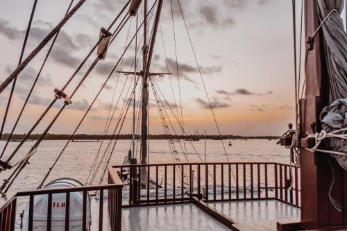a boat on the water with a sunset in the background at Behike Luxury Phinisi in Labuan Bajo