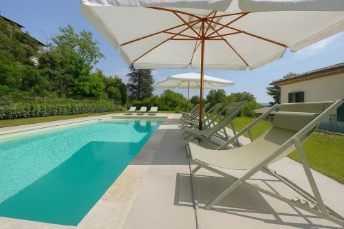 a swimming pool with chairs and an umbrella and a pool at Villa La Gioconda in Arezzo