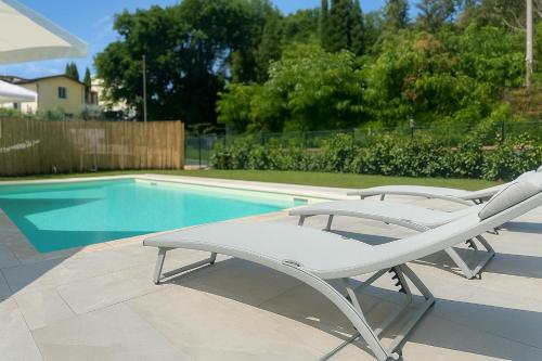 two lounge chairs sitting next to a swimming pool at Villa La Gioconda in Arezzo