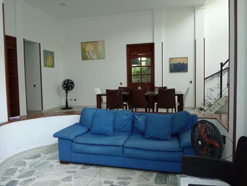 a blue couch in a living room with a table at Hermosa casa en el centro de Ricaurte in Ricaurte