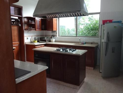 a kitchen with a stove and a refrigerator at Hermosa casa en el centro de Ricaurte in Ricaurte