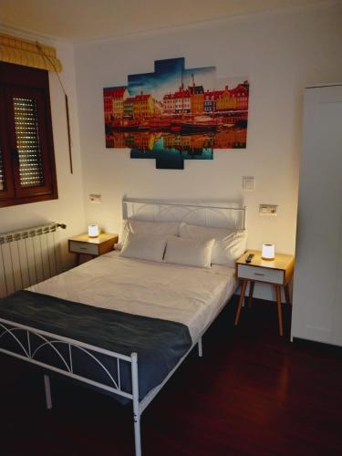 a bedroom with a bed with two tables and a painting on the wall at Casa MARIO y MARIOLA in El Dueso