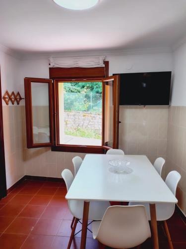 a white table and chairs in a room with a window at Casa MARIO y MARIOLA in El Dueso