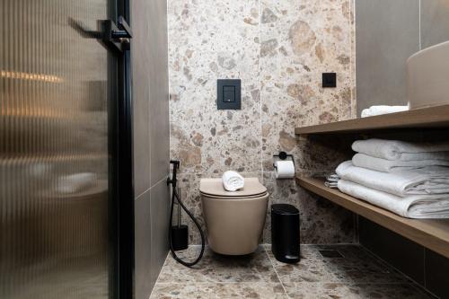 a bathroom with a toilet and some towels at Madonna del Mare City in Chania Town