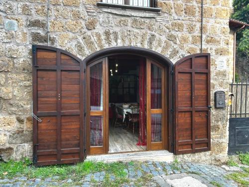 an entrance to a stone building with wooden doors at Etruscan Garden Apartment in Sutri