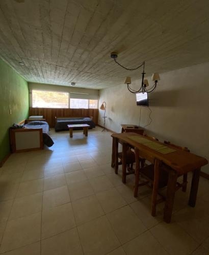 a living room with a table and a couch at Lodge Copahue Expeditions in Caviahue
