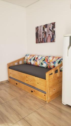 a bed with a wooden frame in a room at N04- Apartmento para 4 pessoas em Jacutinga in Jacutinga
