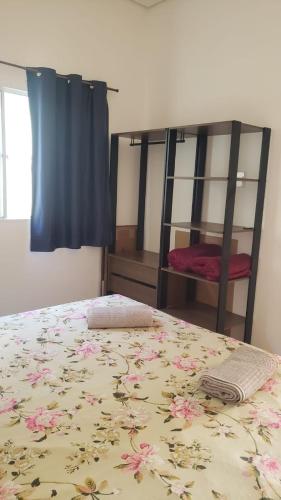 a bedroom with a bed and a bunk bed with flowers on it at N04- Apartmento para 4 pessoas em Jacutinga in Jacutinga